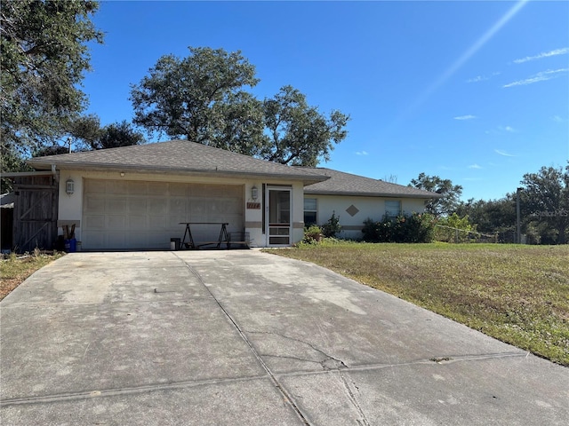 ranch-style house with a garage and a front lawn