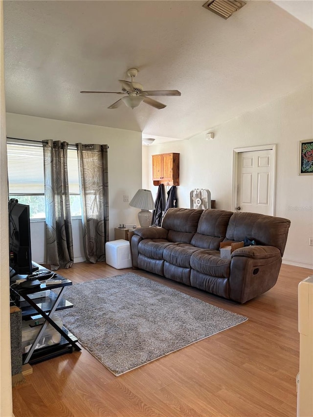 living room with light hardwood / wood-style flooring and ceiling fan