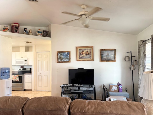 living room featuring ceiling fan, light tile patterned flooring, and vaulted ceiling