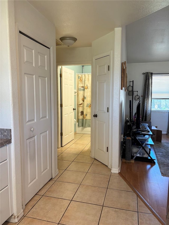 hall with light tile patterned floors