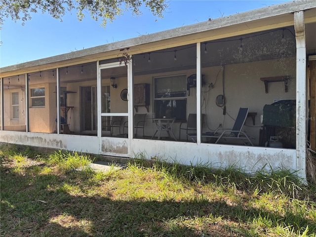 rear view of property featuring a sunroom