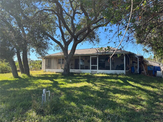 rear view of property with a yard and a sunroom