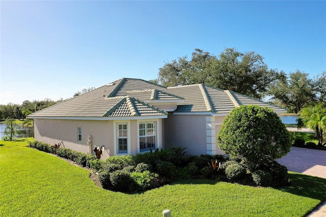 view of side of property featuring a lawn and a water view