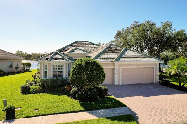 view of front facade featuring a water view, a front yard, and a garage