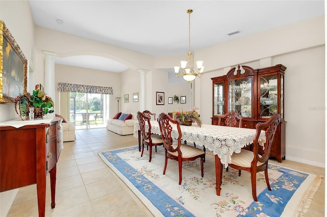 dining space featuring a notable chandelier, light tile patterned flooring, and ornate columns