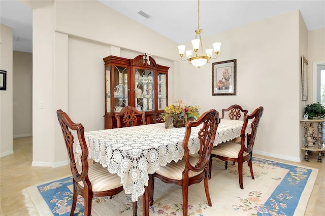 dining space with light tile patterned floors, lofted ceiling, and a notable chandelier