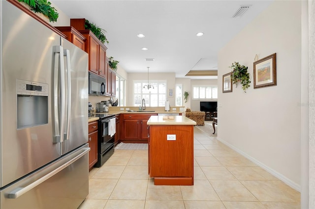 kitchen with black appliances, pendant lighting, light tile patterned floors, a chandelier, and a center island