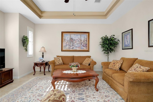 tiled living room featuring a tray ceiling and ceiling fan