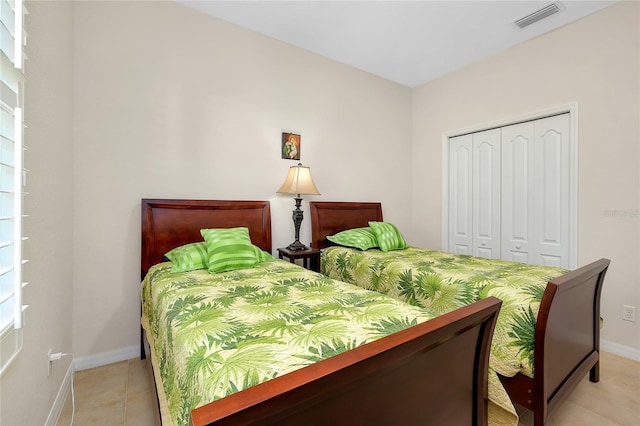 tiled bedroom featuring multiple windows and a closet