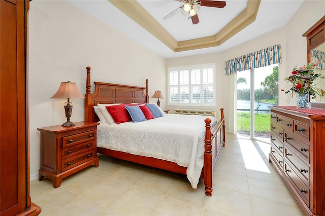 bedroom featuring access to outside, a raised ceiling, ceiling fan, and light tile patterned floors