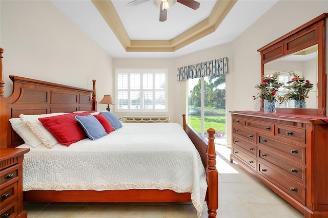 bedroom with a raised ceiling, ceiling fan, and light tile patterned flooring