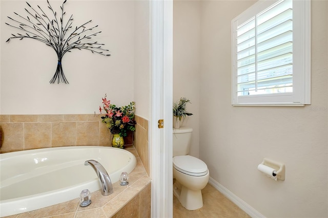 bathroom featuring tiled tub, tile patterned flooring, and toilet