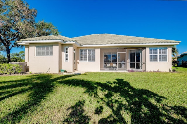 rear view of property with a yard and central AC