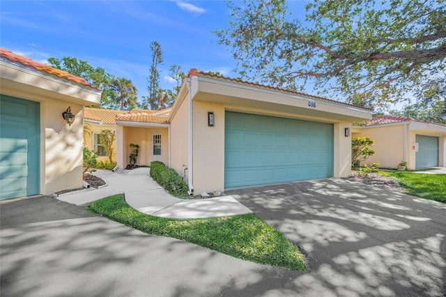 606 Marcus St Unit 26, Venice, FL 34285 - mediterranean / spanish home featuring a tiled roof, stucco siding, driveway, and a garage