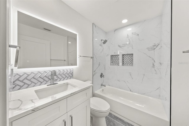 full bathroom with tile patterned flooring, toilet, decorative backsplash, vanity, and tiled shower / bath