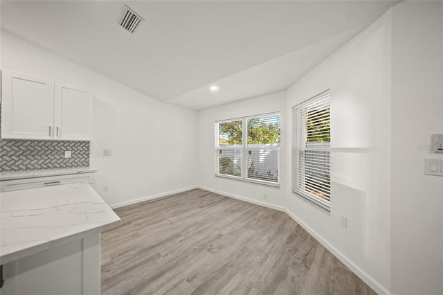 unfurnished dining area featuring light wood-type flooring