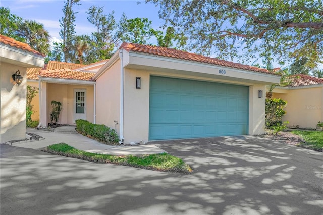 606 Marcus St Unit 26, Venice, FL 34285 - view of front of property with an attached garage, stucco siding, a tile roof, and driveway
