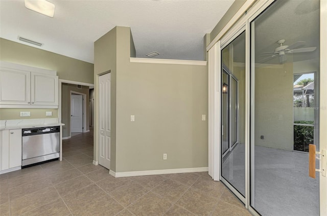 interior space with ceiling fan, stainless steel dishwasher, light tile patterned floors, and white cabinets