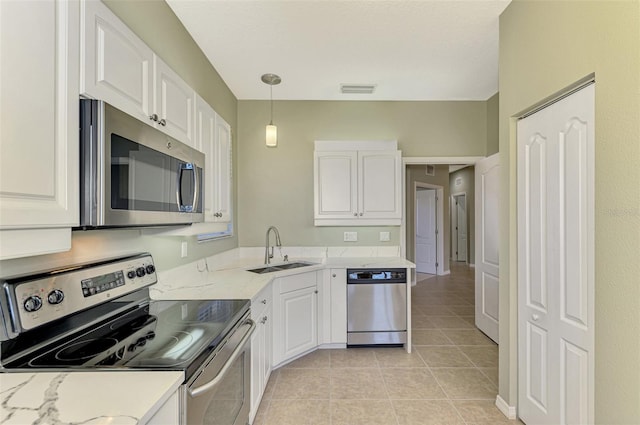 kitchen with sink, stainless steel appliances, hanging light fixtures, and white cabinets