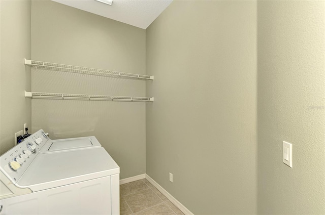 clothes washing area with independent washer and dryer and light tile patterned floors