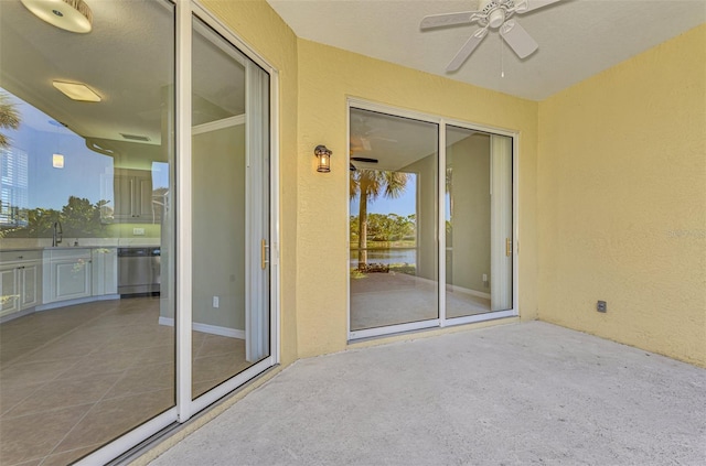 exterior space with a water view, sink, and ceiling fan