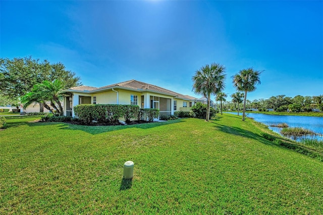 view of front of property featuring a water view and a front lawn