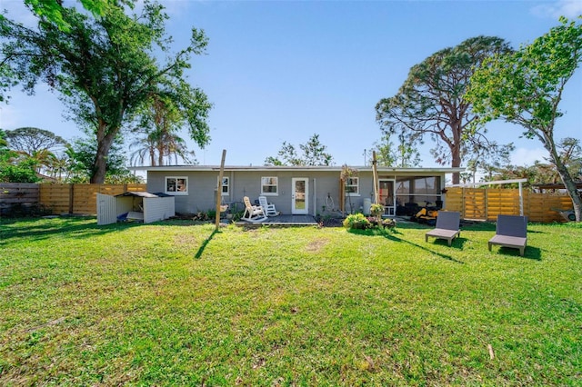 back of house featuring a sunroom and a lawn