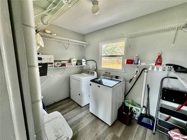 laundry room featuring washing machine and dryer, a textured ceiling, and hardwood / wood-style floors