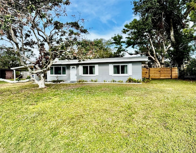 ranch-style home featuring a front lawn and a carport