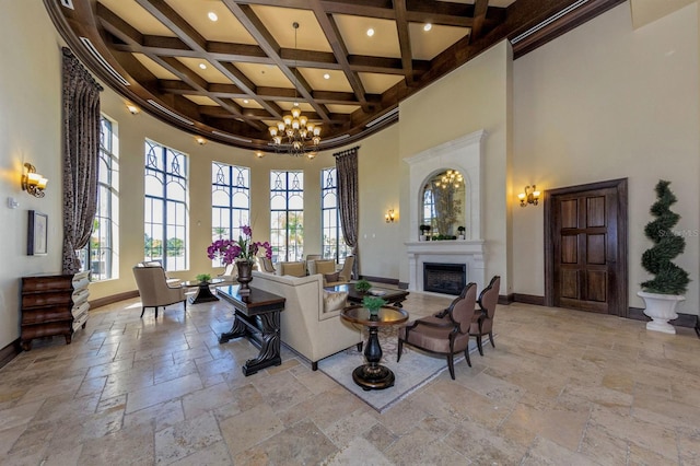 living room with a high ceiling, an inviting chandelier, coffered ceiling, and beam ceiling