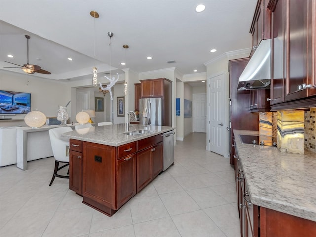 kitchen with backsplash, stainless steel appliances, sink, pendant lighting, and a center island with sink