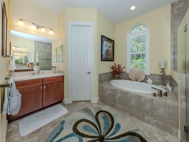 bathroom featuring vanity and tiled bath