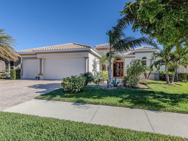 mediterranean / spanish-style home with a front yard and a garage