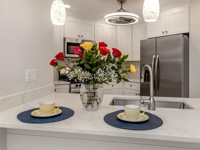 kitchen with pendant lighting, stainless steel appliances, and white cabinetry