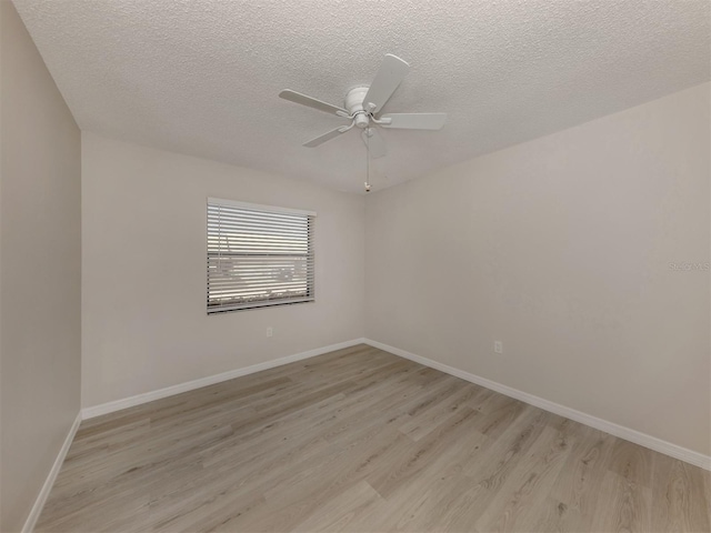 spare room featuring a textured ceiling, light wood-type flooring, and ceiling fan