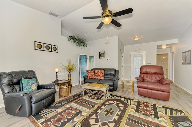 living room with ceiling fan, light hardwood / wood-style floors, and lofted ceiling