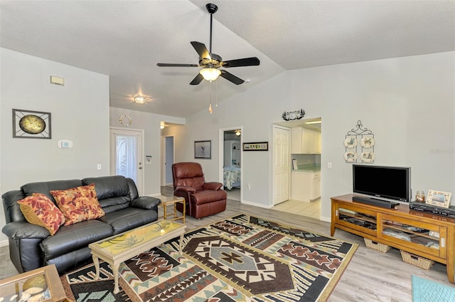 living room featuring ceiling fan, vaulted ceiling, and hardwood / wood-style flooring