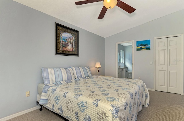 carpeted bedroom with ceiling fan, vaulted ceiling, ensuite bathroom, and a closet