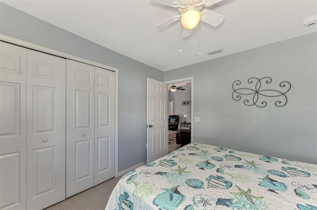 bedroom featuring ceiling fan, light carpet, and a closet