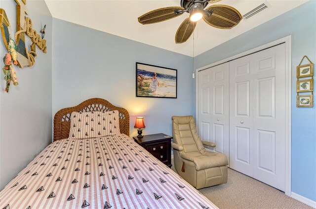 carpeted bedroom with ceiling fan and a closet