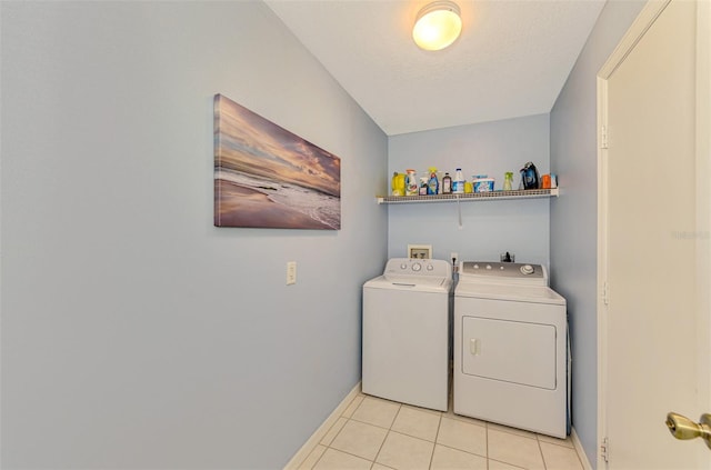 clothes washing area featuring light tile patterned flooring, a textured ceiling, and independent washer and dryer