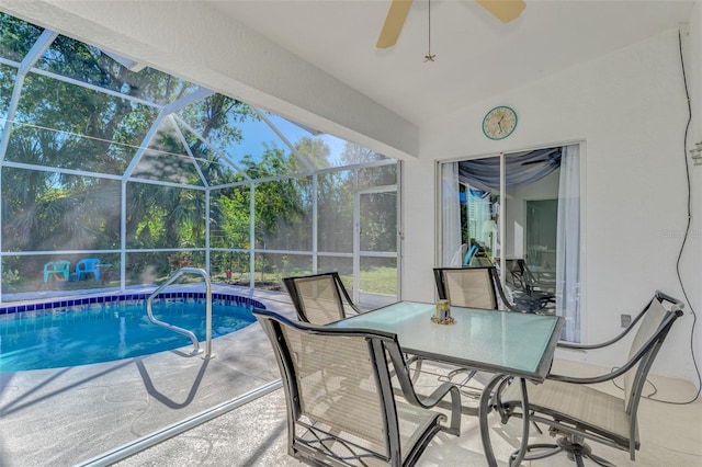 view of swimming pool featuring glass enclosure, ceiling fan, and a patio area