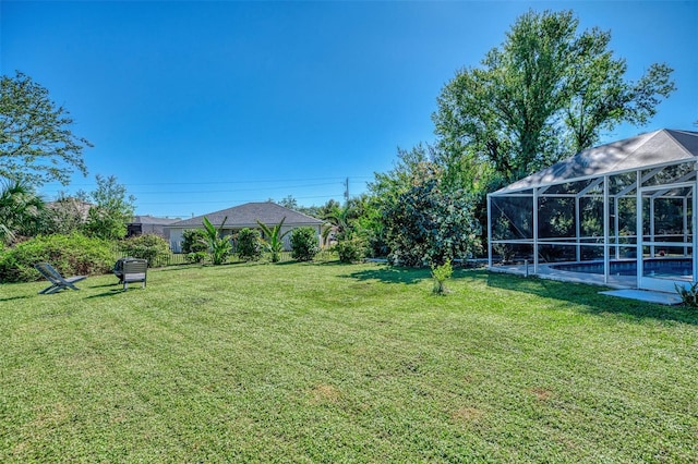 view of yard featuring glass enclosure and a swimming pool