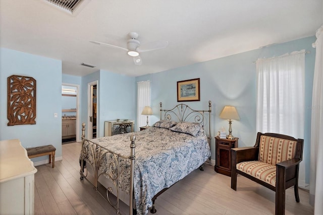 bedroom featuring ensuite bath, ceiling fan, a spacious closet, light hardwood / wood-style flooring, and a closet