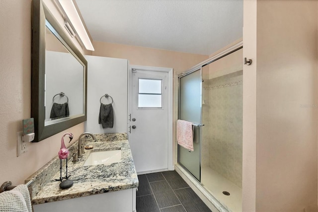 bathroom featuring vanity and a shower with door