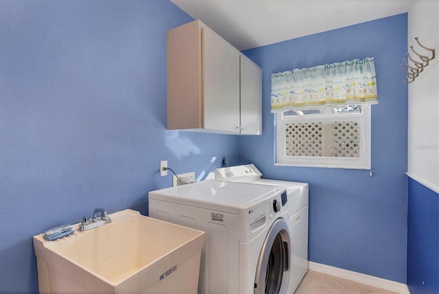 washroom with washing machine and clothes dryer, sink, light tile patterned floors, and cabinets