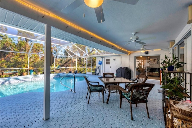 view of swimming pool featuring a patio area, ceiling fan, a lanai, and a grill