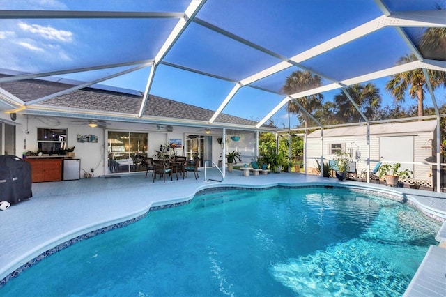 view of swimming pool with glass enclosure, ceiling fan, a patio area, and a grill