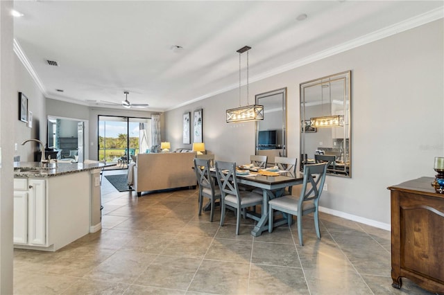 tiled dining area with ceiling fan, sink, and ornamental molding