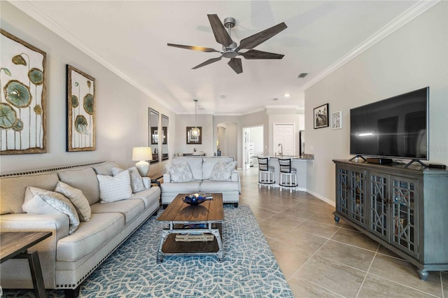 tiled living room with ceiling fan and ornamental molding